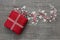 Red valentines present with checked ribbon and hearts on grey wooden background.