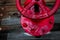 A red valve on the wooden deck of a battleship.