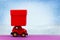 Red velour toy car with red gift box for Christmas, new year, Valentine`s day, birthday on winter snow background