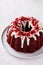 Red velvet bundt cake with cream cheese frosting and cake crumbs