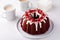 Red velvet bundt cake with cream cheese frosting and cake crumbs