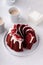 Red velvet bundt cake with cream cheese frosting and cake crumbs