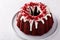 Red velvet bundt cake with cream cheese frosting and cake crumbs