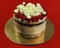 Red velvet cake close up on a golden pedestal and red background