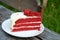 Red velvet cheese cake in a white dish on wood table in a garden style coffee shop