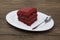 Red Velvet, fresh delicious diet cake at Dukan Diet on a porcelain plate with a spoon on a wooden background.