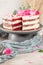 Red velvet naked cake with fresh roses and swiss buttercream on kitchen countertop