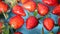 Red vibrant strawberries floating on the water