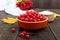 Red viburnum in a ceramic bowl, sugar, a bunch of berries for tea, jam