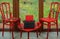 Red Viennese chairs and a typewriter by the window overlooking the autumn garden