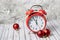 Red vintage alarm clock on a wooden table decorated with a garland and red Christmas balls for the New Year or XMAS. Mail, courier