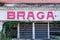 Red vintage braga sign on old abandoned building with naco windows