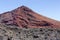 Red volcano near Los Hervideros caves in Lanzarote, Canary Islands.