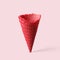 Red wafer ice cream cone on a pink background. Minimalistic concept