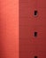 Red wall of building facade with small windows. Conceptual abstract shot