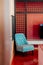 Red wall Living room with contemporary furnitures, colourful armchairs and wood partition