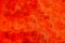 Red wall painted with strong red and orange vivid colours as colourful metallic surface texture background