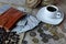 Red wallet with american dollars, various foreign coins and cup of coffee on the table