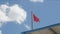 Red warning flag flapping in the wind over blue sky. Swimming is dangerous in ocean waves. Red flag flying in slow motion in a