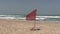 Red warning flag flying on a deserted beach