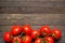 Red washed ripened tomatoes in bottom part of wooden background
