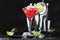 Red Watermelon alcoholic cocktail with vodka, juice, lime and crushed ice, metal bar tools, dark background