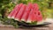 Red watermelon slices on a plate with mint leaves.