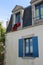 A red wetsuit is drying at the window of a house (France)