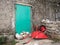 Red wheelbarrow lying on the floor in front of a green door