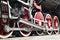 Red wheels of old USSR black steam locomotive. Wheels of an old soviet steam trai