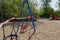 Red and white alarm caution tape wrapped around outdoor swings during global quarantine from COVID-19