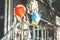 Red and white balloons are attached to the porch railing. Store opening. Bright sunlight and shadows.