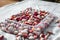 Red and white beans in a plastic tray. Drying and storing the colored beans at home. Selective focus