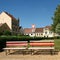 Red-and-white benches are sitting in the centre of small village in Europe. Contrasting and noticeable scene