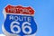 Red, white and blue Route 66 sign in front of blue sky