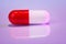 Red and white bolus (capsule) on violet