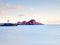 Red white buildings and lighthouse in small port, coastline of cold north sea, Norway.