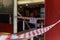 Red and white caution tape restrict outdoor eating area of cafe and restaurant which closed during epidemic of COVID-19