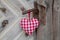 Red/white checkerd heart shape hanging on rusty door handle in c