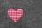 Red and white checkered heart on grey felt background