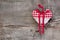 Red/white checkered heart shape hanging on a wooden background f