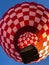 Red and white checkered hot air balloon by blue sky