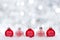 Red and white Christmas ornaments with twinkling silver background