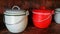 Red and white coated pot with handle on wooden