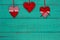 Red and white country hearts hanging by ribbon on antique teal blue sign