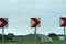 Red and white direction warning sign post on curve bend in road pointing left to right