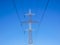 Red white electricity pylon against blue sky