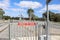 Red and white Emergency Exit sign with arrow on a gate at a pedestrian crossing