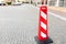 Red and white flat parking bollard on the road near the apartment