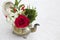 Red and White floral arrangement in antique teapot